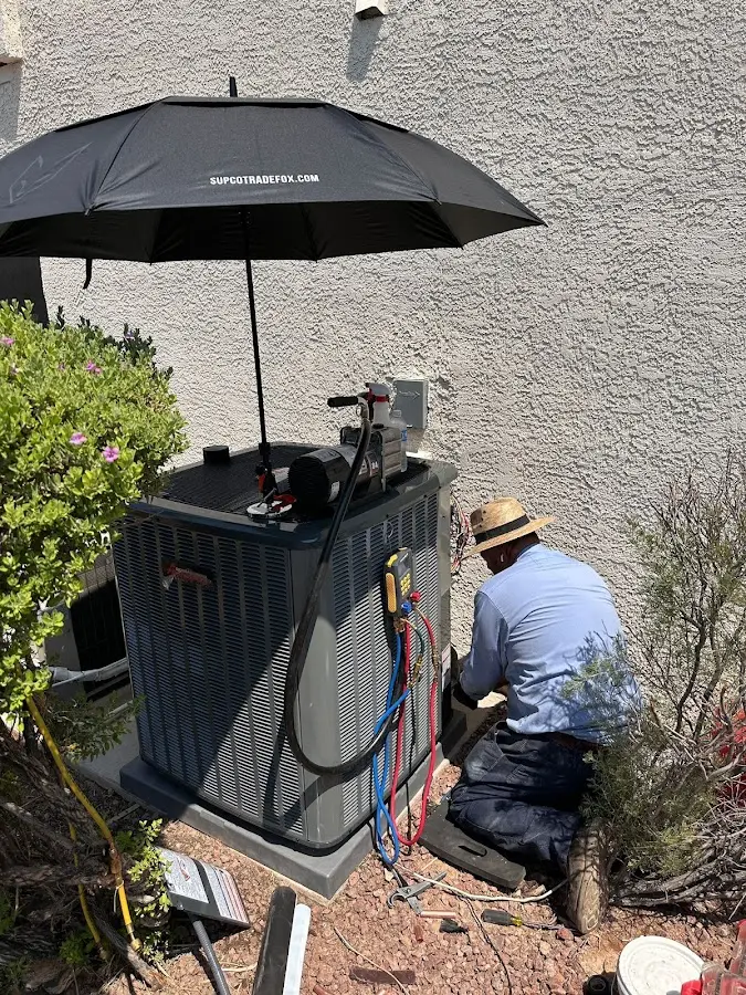 HVAC technician performing outdoor AC maintenance in Jackson